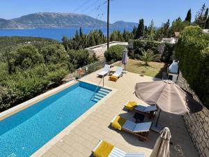 a villa with a swimming pool and a view of the water at Villa Vassilis Fiscardo Kefalonia in Katsaráta