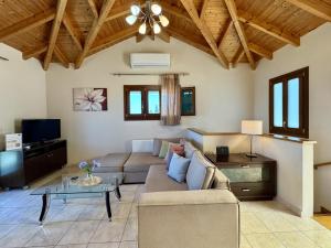 a living room with a couch and a table at Villa Vassilis Fiscardo Kefalonia in Katsaráta