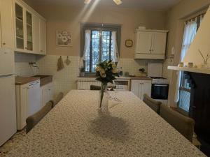a kitchen with a table with a vase of flowers on it at il nuvoloso in Città della Pieve +24 photos