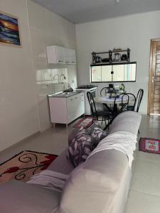 a living room with a couch and a kitchen at Apartamento Aconchego II in Alta Floresta +15 photos