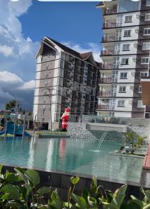 a large apartment building with a fountain in a pool at Antara Condominium Tower 2 in Talisay