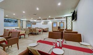 a dining room with tables and chairs in a restaurant at Hotel Hill Palace in Jāmb