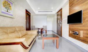 a living room with a couch and a tv at Hotel Hill Palace in Jāmb