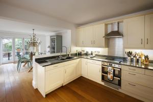 a kitchen with white cabinets and black counter tops at Stylish, Spacious, Oxford Townhouse, Driveway parking in Oxford +27 photos