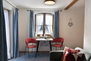 a living room with a table and chairs and a window at Bergleuchten -403- in Krün
