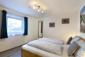 a bedroom with a bed and a window at Bergleuchten -403- in Krün +15 photos