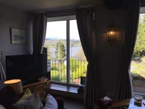 a living room with a large window with a view at Artie's Lodge in Windermere
