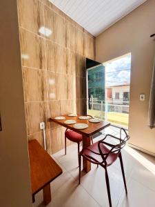 a dining room with a table and chairs and a window at Apartamento juçara Lençóis in Barreirinhas