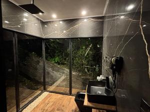 a bathroom with a sink and a large window at Piramidevidro in Santa Isabel +26 photos