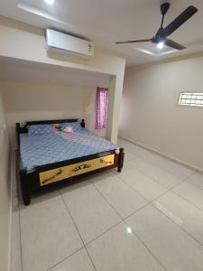 a bedroom with a bed and a ceiling fan at Hotel Homestay-Bhimavaram in Bhīmavaram