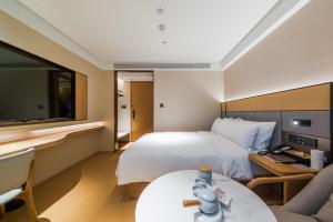 a hotel room with a large bed and a couch at JI Hotel Beijing Station in Beijing