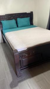 a bed with a wooden frame with blue pillows at Hostel La Suerte in Monteverde Costa Rica