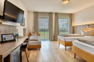 a hotel room with two beds and a flat screen tv at Landhotel Seerose in Langenzenn +128 photos