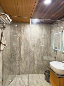 a bathroom with a glass shower and a sink at Hotel Heritage Inn in Samastīpur