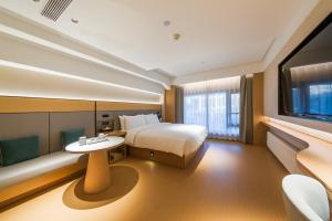 a hotel room with a bed and a table and a tv at JI Hotel Beijing Station in Beijing
