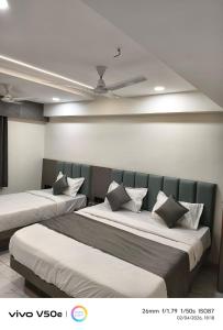 a bedroom with two beds and a ceiling at Hotel 7 CR in Ahmedabad