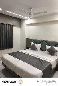 a bedroom with a large bed with a ceiling at Hotel 7 CR in Ahmedabad +7 photos