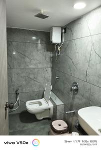 a bathroom with a toilet and a sink at Hotel 7 CR in Ahmedabad