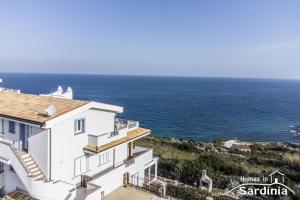 a white house with a view of the ocean at Tra blu e celeste in Castelsardo