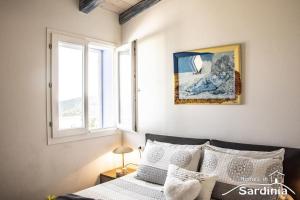 a bedroom with a bed and two windows at Tra blu e celeste in Castelsardo