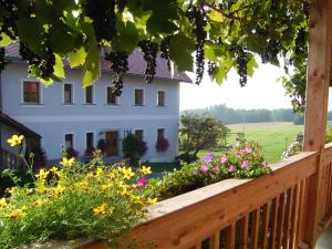 eine Veranda mit Blumen und ein weißes Haus in der Unterkunft Hanauerhof in Schönsee