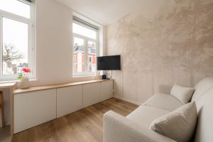 a living room with a couch and a tv at Le Cocoon Studio 2 voyageurs in Arras