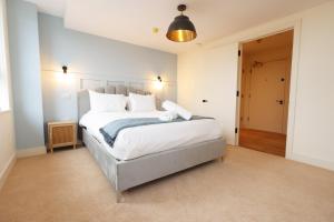a bedroom with a large bed with white sheets and pillows at The Swansea Central Hall 1 Bed Room Apartment in Swansea +22 photos