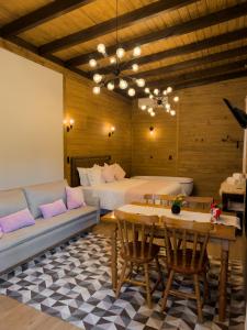 a room with two beds and a couch and a table at Pousada Duas Marias in Nova Veneza