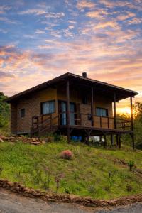 a house on a hill with a sunset in the background at Pousada Duas Marias in Nova Veneza