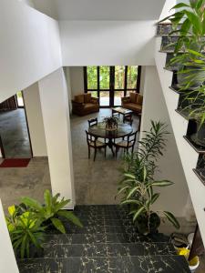 a hallway with a table and potted plants at Belgi Guest House in Balapitiya