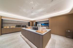 a large kitchen with a counter with food at JI Hotel Beijing Station in Beijing