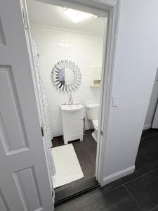 a white bathroom with a sink and a mirror at Comfortable 2BR & 2 Bath Apt in Downtown NYC in New York