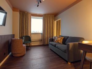 a living room with a couch and a window at Elite Hotel Arcadia in Stockholm
