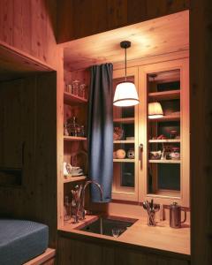 a kitchen with a sink and a window at minipockethouse in Evolène