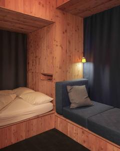 a bedroom with two beds and a chair in it at minipockethouse in Evolène