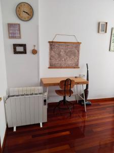 a room with a desk and a radiator and a clock at María II in Ferrol