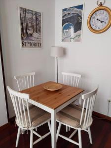 a dining room table with chairs and a clock on the wall at María II in Ferrol
