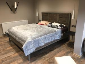 a bedroom with a large bed with a wooden headboard at Apartmány Za Zvončekom in Vydrná