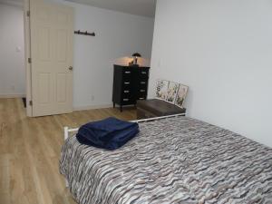 a bedroom with a bed and a dresser and a door at Small comfortable apartment in Saint-Nazaire