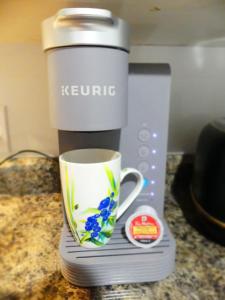 a coffee maker with a coffee cup on a counter at Small comfortable apartment in Saint-Nazaire