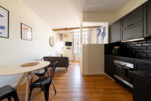 a kitchen with a table and chairs and a kitchen with a refrigerator at Best Place - Studio hyper centre ville d'Arras in Arras