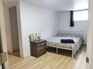 a bedroom with a bed and a dresser and a window at Small comfortable apartment in Saint-Nazaire