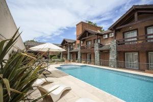 a swimming pool in front of a building at Aguas Claras Hosteria in Santa Rosa de Calamuchita