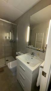a bathroom with a sink and a toilet and a mirror at Petit Rosselló in Barcelona +26 photos