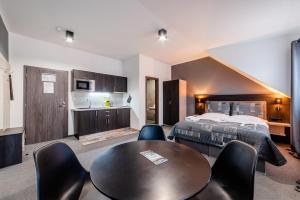 a hotel room with a bed and a table and chairs at Třeboňské Apartmány in Třeboň