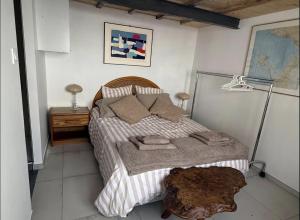 a bedroom with a bed and a table with a lamp at L'escale les pieds dans l'eau in Barbâtre