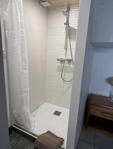 a shower with a shower curtain in a bathroom at L'escale les pieds dans l'eau in Barbâtre