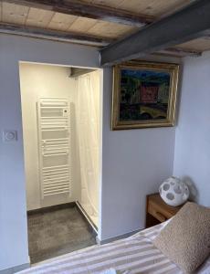 a bedroom with a bed and a painting on the wall at L'escale les pieds dans l'eau in Barbâtre