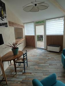 a living room with a table and chairs and windows at Studio cosy in Champs