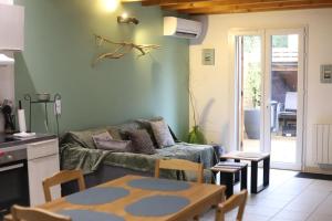 a living room with a couch and a table at Maison Cléophée in Gujan-Mestras